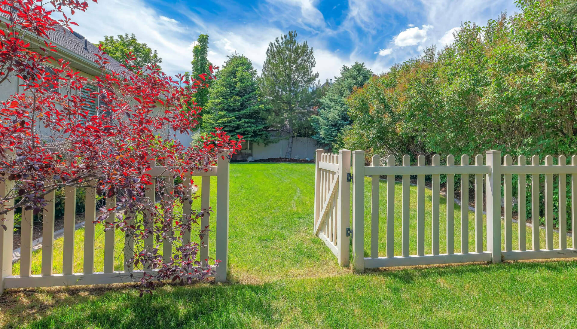 A functional fence gate providing access to a well-maintained backyard, surrounded by a wooden fence in Columbus